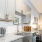Kitchen with grey cabinets, white backsplash and gooseneck faucet